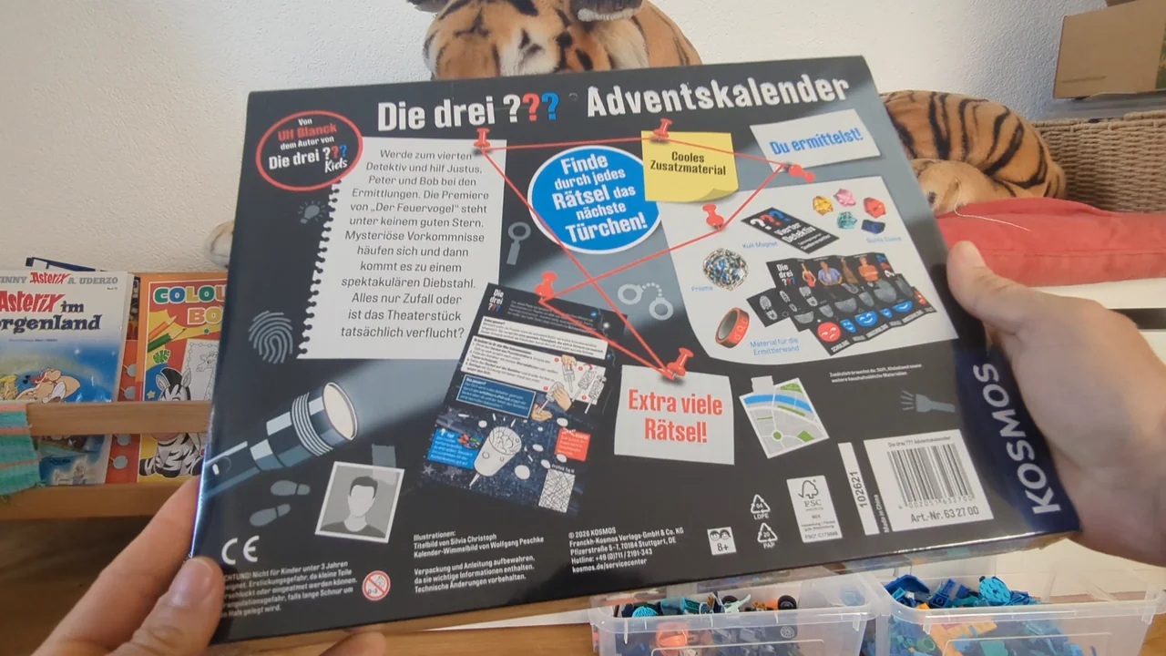 Die Rückseite zeigt das Zusatzmaterial: Kult-Magnet, Prisma, bunte Steine und Material für die Ermittlerwand.