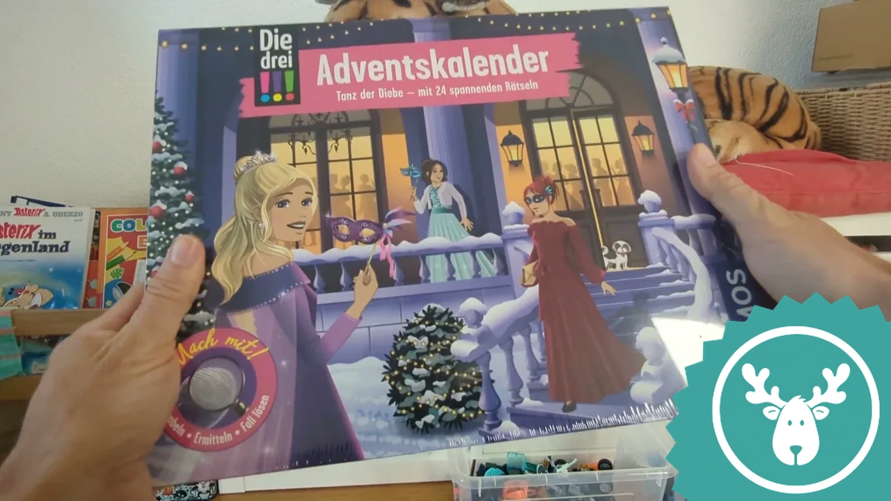 Auf der Vorderseite sind die drei Detektivinnen Kim, Franzi und Marie beim weihnachtlichen Maskenball vor der Oper zu sehen.
